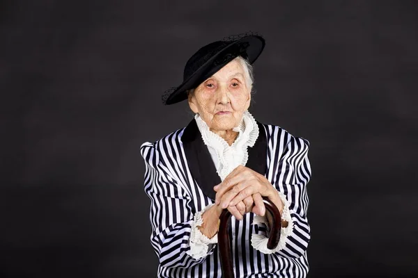 Stylish old woman on black background