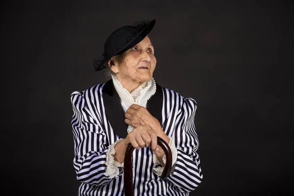 Stylish old woman on black background