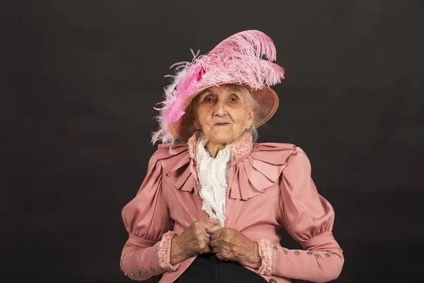 Stylish old woman on black background