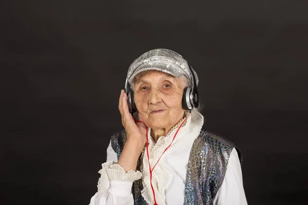 Stylish old woman on black background