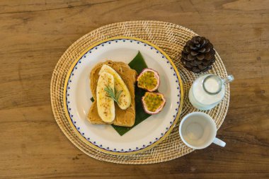 süt ve fıstık ezmesi muz ekmek ve tutku meyve kahvaltı