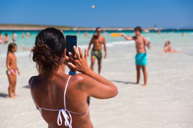 Stintino, İtalya - 21 Ağustos 2017 - kimliği belirsiz bir kadın ünlü La Pelosa Beach Adası Sardunya resim insanlar almak.