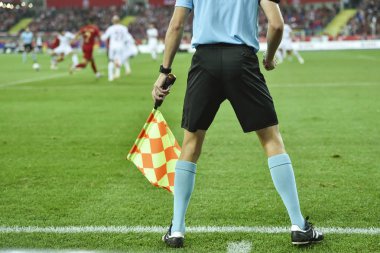 Assistant of football referee with the flag on the touch line.
