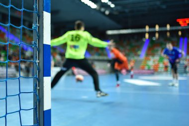 Hentbol kale direğinin ayrıntıları ve arka planda hentbol maçı.