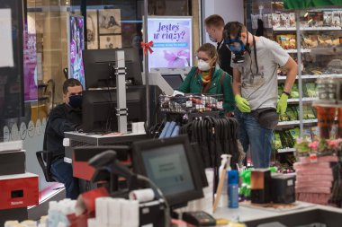 WROClaw, POLAND - 22 Mayıs 2020. Dükkandaki kasanın önündeki müşteriler. Koronavirüs salgınından dolayı insanların yüz maskeleri vardır..