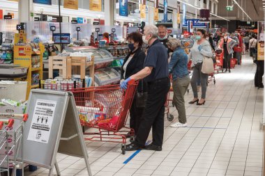 WROClaw, POLAND - 22 Mayıs 2020. Carrefour süpermarketindeki kasa kuyruğundaki müşteriler. Koronavirüs salgınından dolayı insanların yüz maskeleri vardır..