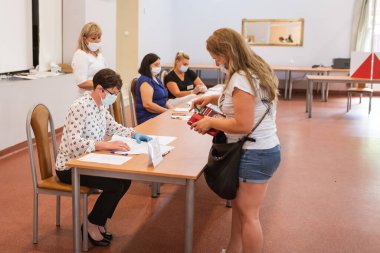 SCINAWA, POLAND - 28 Haziran 2020: Polonya cumhurbaşkanlığı seçimleri sırasında seçim komisyonu ve seçmen.