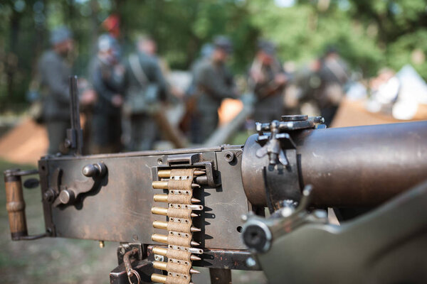 Detail of ammunition for a heavy machine gun from I Word War with a military camp in the background