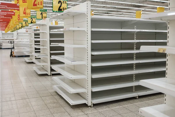 Süpermarkette boş raflar. En üstte, Polonya fiyatları ve altyazı.