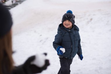 Dışarıda kartopu oynayan genç bir çocuk