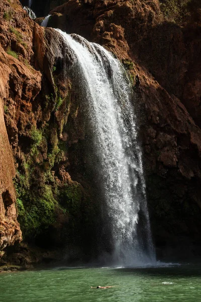 Fas 'ta güzel Ouzoud suları altında rahat bir kadın sırtüstü yüzüyor..