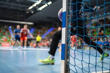 Hentbol kalesinin ayrıntıları top ona çarptığında. Arka planda hentbol maçı