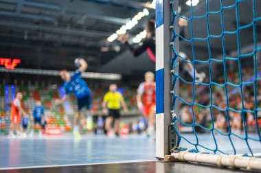 Hentbol kale direğinin ayrıntıları ve arka planda hentbol maçı