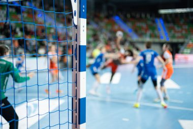 Hentbol kale direğinin ayrıntıları ve arka planda oyuncular.