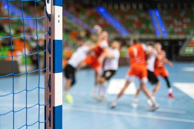 Hentbol kale direğinin ayrıntıları ve arka planda oyuncular.