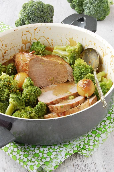 Sosla kaplı bir tencerede brokoli ile pişirilmiş et. Sulu doku ve iştah açıcı servis ev yapımı sıcak bir atmosfer yaratır..