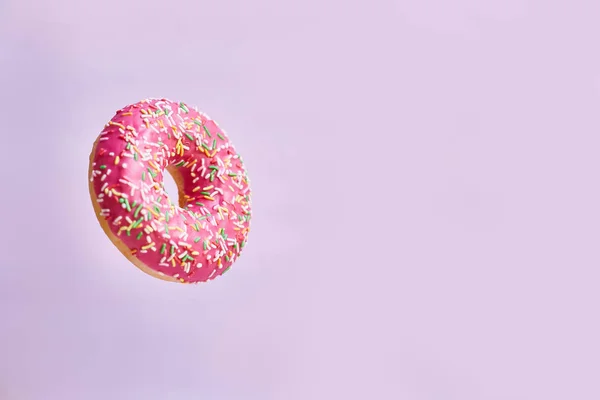 Pink donut on a pink background. Space for text