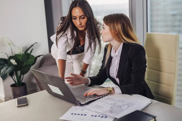 Ung kvinnlig assistent consulting med en top manager visar data på laptop skärm och be om råd sitter på arbetsplats — Stockfoto