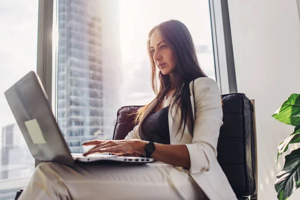 Ung kvinna som arbetar på laptop sitta hemma — Stockfoto