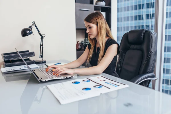 Mujer trabajando con documentos sentada en el escritorio en la oficina — Foto de Stock