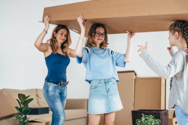 Aile yeni evinde karton kutuları açıyor