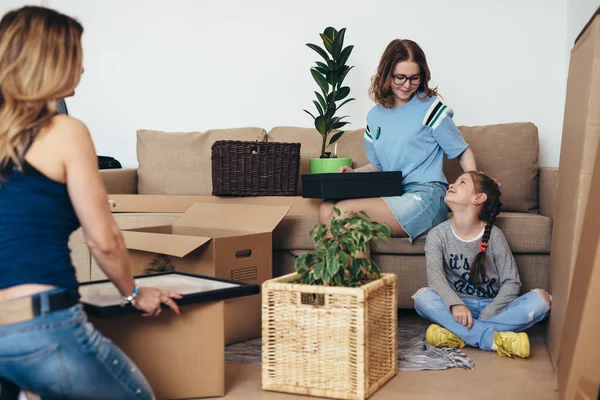 Μητέρα δύο παιδιών στο νέο σπίτι με κουτιά από χαρτόνι. — Φωτογραφία Αρχείου