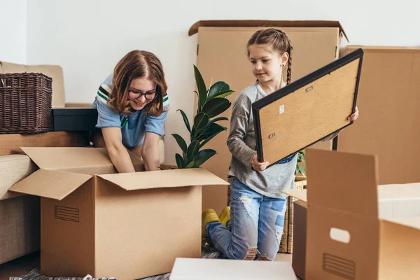 Family unpacking cardboard boxes at new home