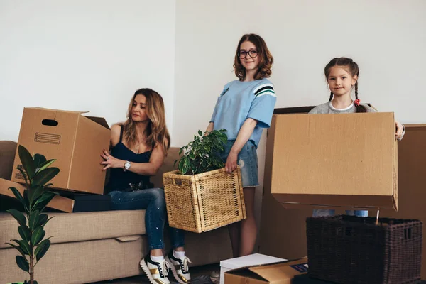 Family with cardboard boxes in new house at moving day