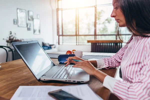 Laptop számítógéppel otthon dolgozó fiatal nő — Stock Fotó