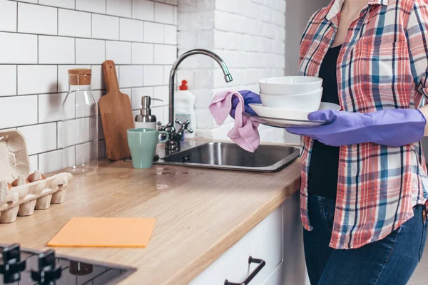 Kobieta, wycierając czystą płytkę z ręcznikiem w kuchni. — Zdjęcie stockowe