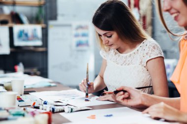 İki yetişkin erkek öğrenciler Sanat okulunda okuyan onların resimleri üzerinde çalışıyor