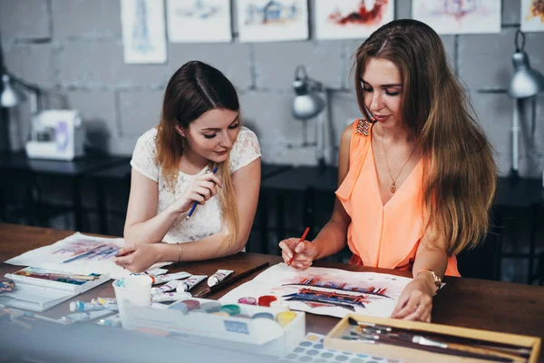 İki yetişkin erkek öğrenciler Sanat okulunda okuyan onların resimleri üzerinde çalışıyor