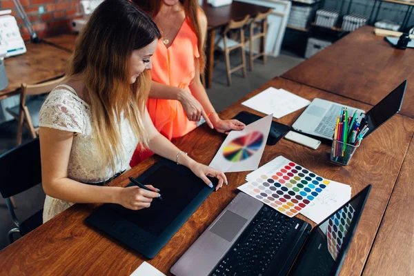 Diseñadora femenina trabajando con el cliente en el escritorio de su oficina — Foto de Stock