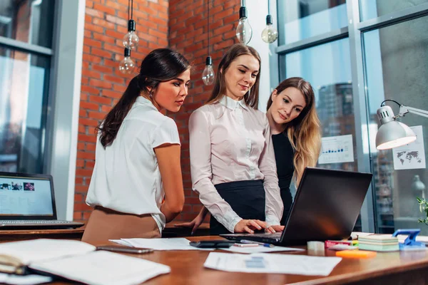 Mulher com colegas de laptop em pé no escritório — Fotografia de Stock