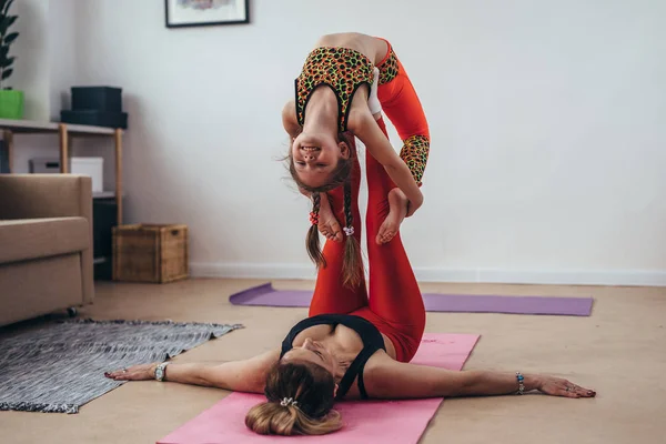 Mor och daughterdoing gymnastiska övningar tillsammans hemma — Stockfoto