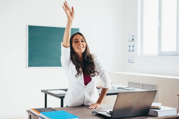 Female student raises hand sitting at the desk like a pupil. — Stock Photo, Image