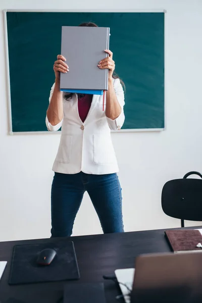 Studentin steht mit Buch neben Tafel. — Stockfoto