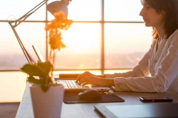 Employée concentrée tapant sur le lieu de travail à l'aide d'un ordinateur. Vue de côté portrait d'un rédacteur travaillant sur PC à la maison . — Photo