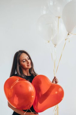 Gülümseyen şirin esmer kadın ayakta ve balon ile oynama.