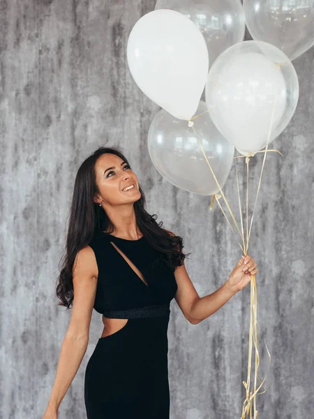 Fröhliche junge Frau mit Luftballons stehend und lächelnd — Stockfoto