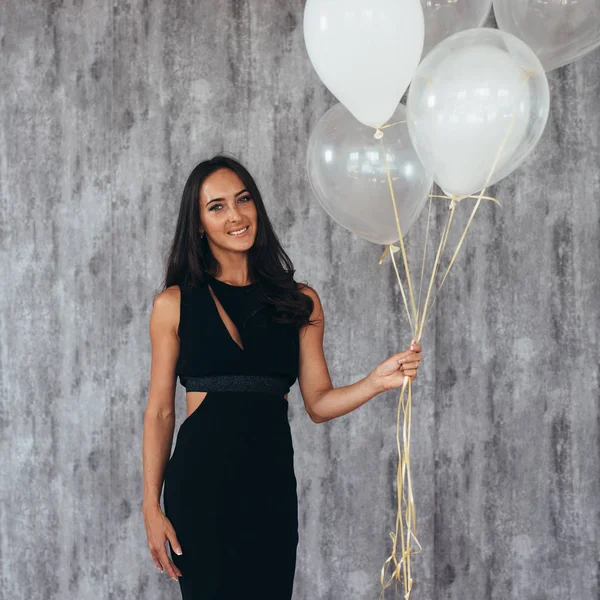 Glad ung kvinna med ballonger står och ler — Stockfoto