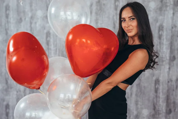 Vrolijke jonge vrouw met ballonnen permanent en glimlachen — Stockfoto