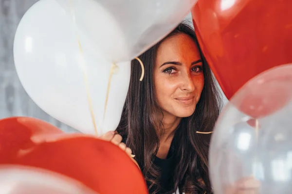 Joven alegre con globos de pie y sonriendo —  Fotos de Stock