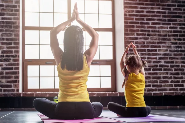 Rara vista de dos chicas practicando yoga sentadas en pose de loto meditando —  Fotos de Stock