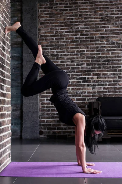 Elején női jógi gyakorló jóga inverzió jelent kezét fejjel lefelé hajló fitness Club falnak állandó — Stock Fotó