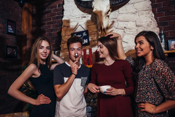 Cuatro adolescentes guays que usan ropa casual posando para la cámara en un elegante diseño de interiores con pabellón de caza . —  Fotos de Stock