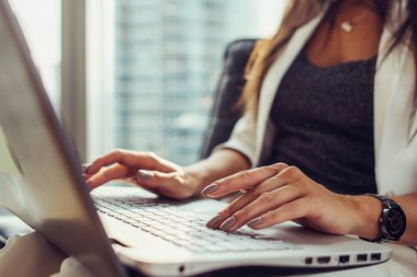 Eller klavye kadın ofiste oturan netbook kullanarak görmek