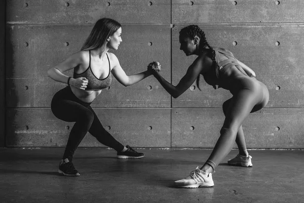 Fit mulher wrestle em mãos com um adversário feminino olhando em seus olhos . — Fotografia de Stock
