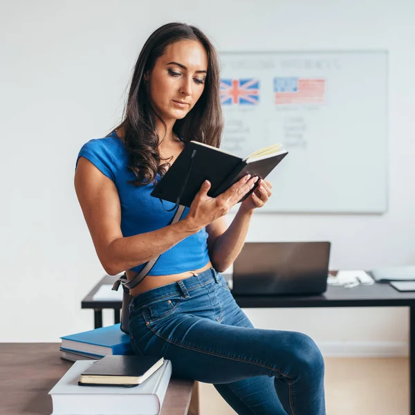 Estudante feminina sentada à mesa livro de leitura . — Fotografia de Stock