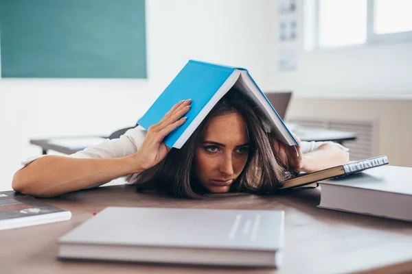 Mujer joven cansada durmiendo en el escritorio con libros — Foto de Stock